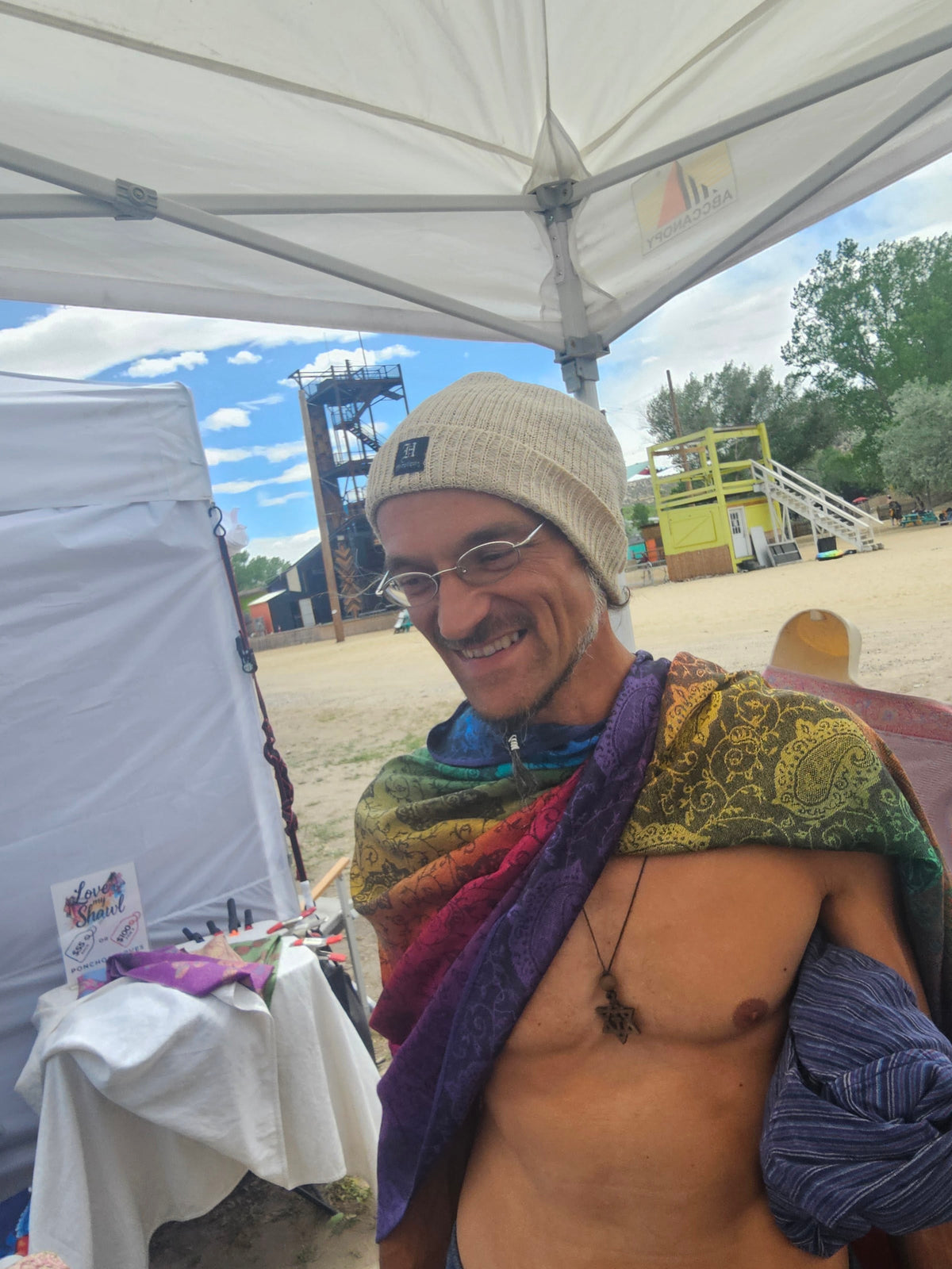 Rainbow Paisley poncho scarf flipped over the shoulder at a festival