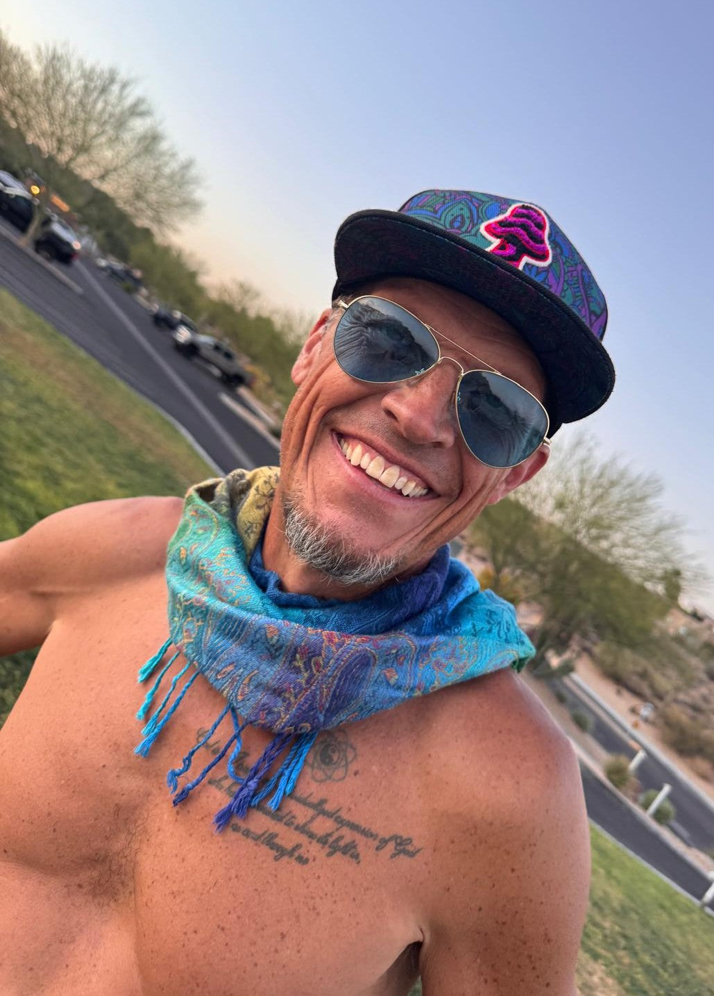 Rainbow Paisley poncho scarf worn as a bandana at a festival