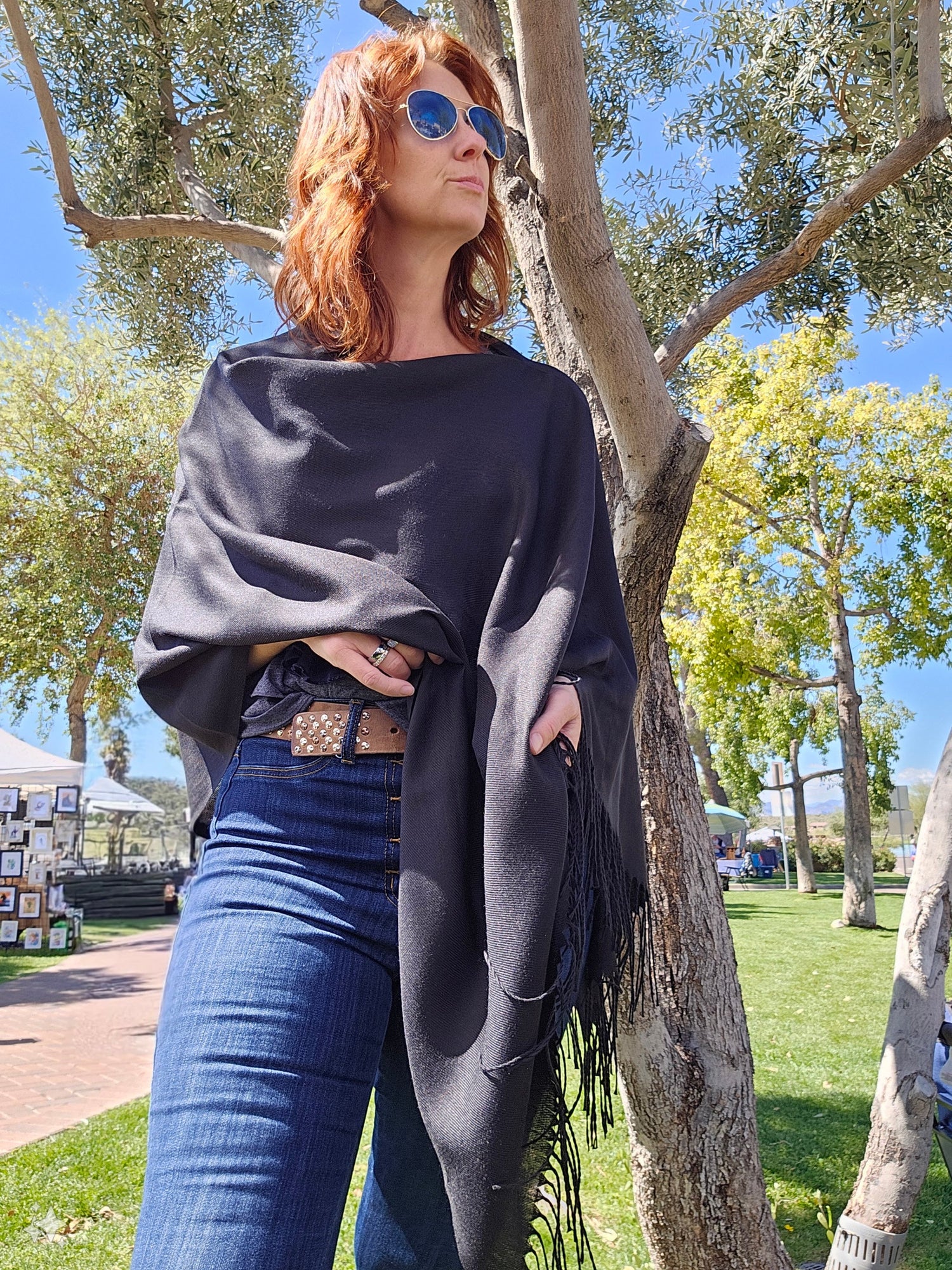 Model wearing the solid black poncho scarf over jeans
