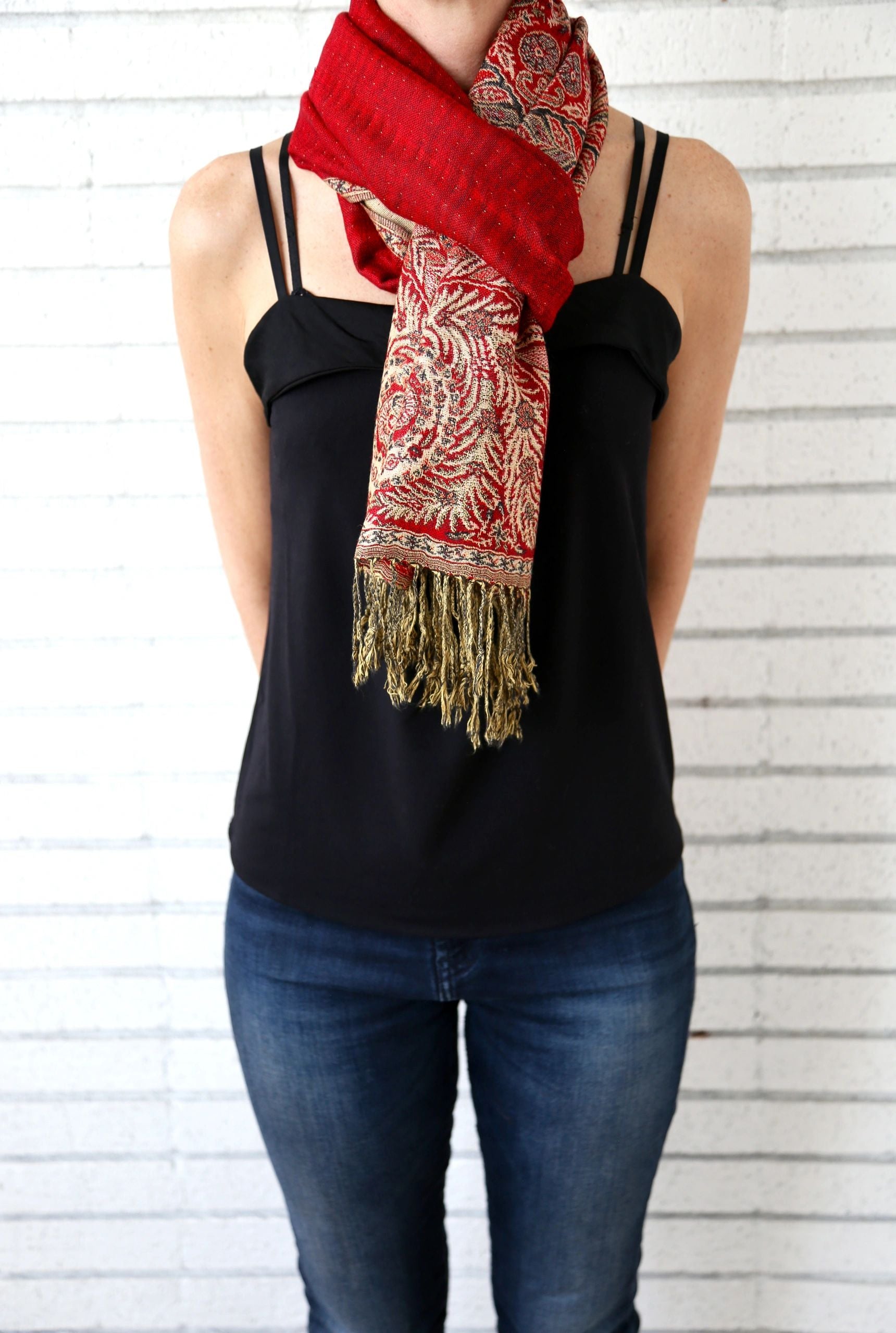 Red paisley poncho scarf worn looped around the neck as a scarf