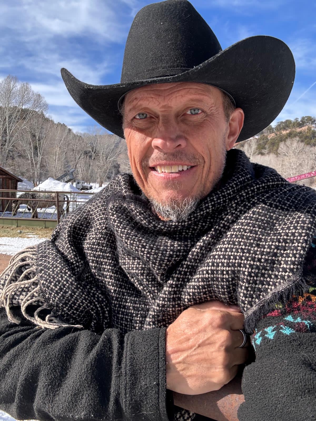 Man wearing the black Cozy Fuzzy poncho scarf outdoors
