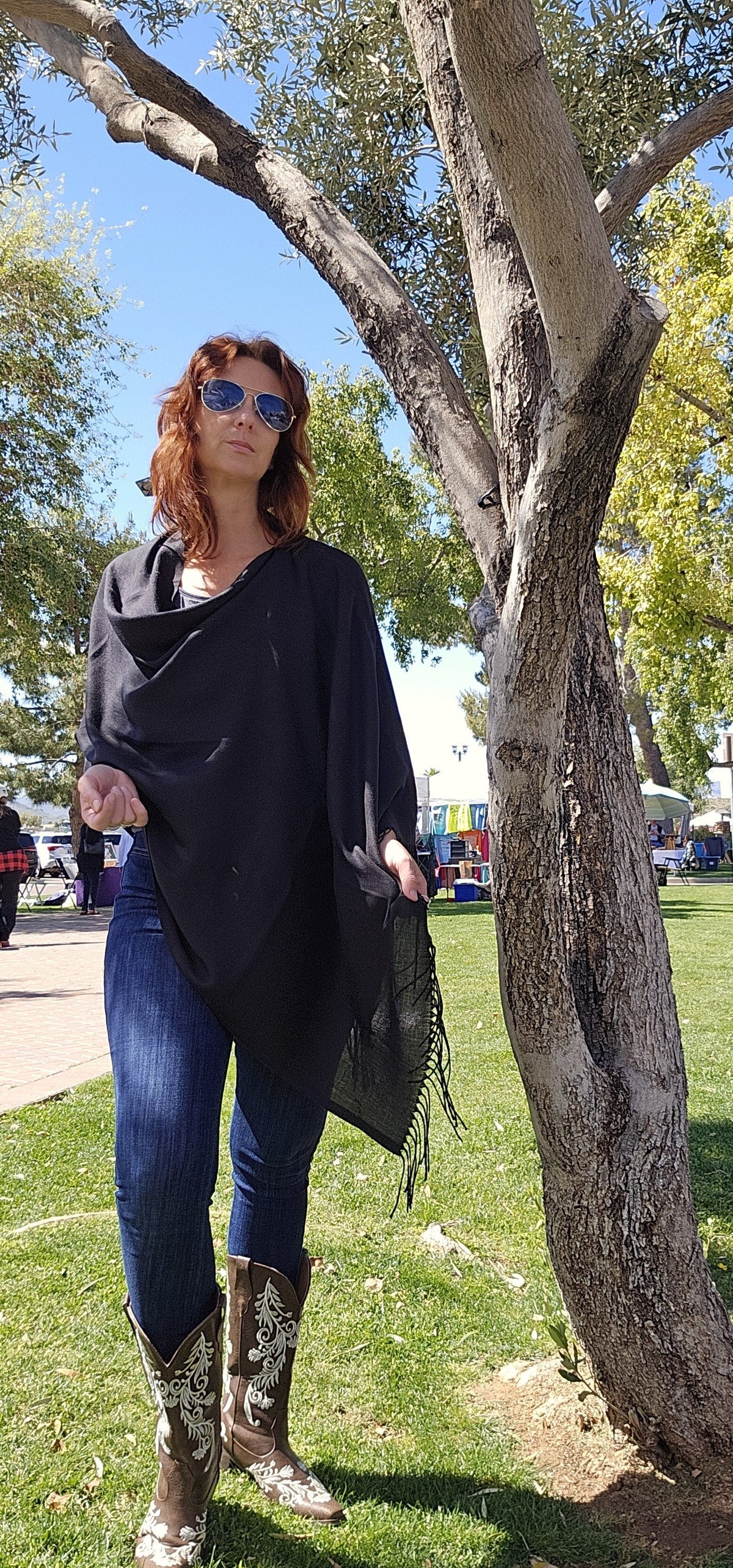 Black poncho scarf worn with the seam at the side for an even drape