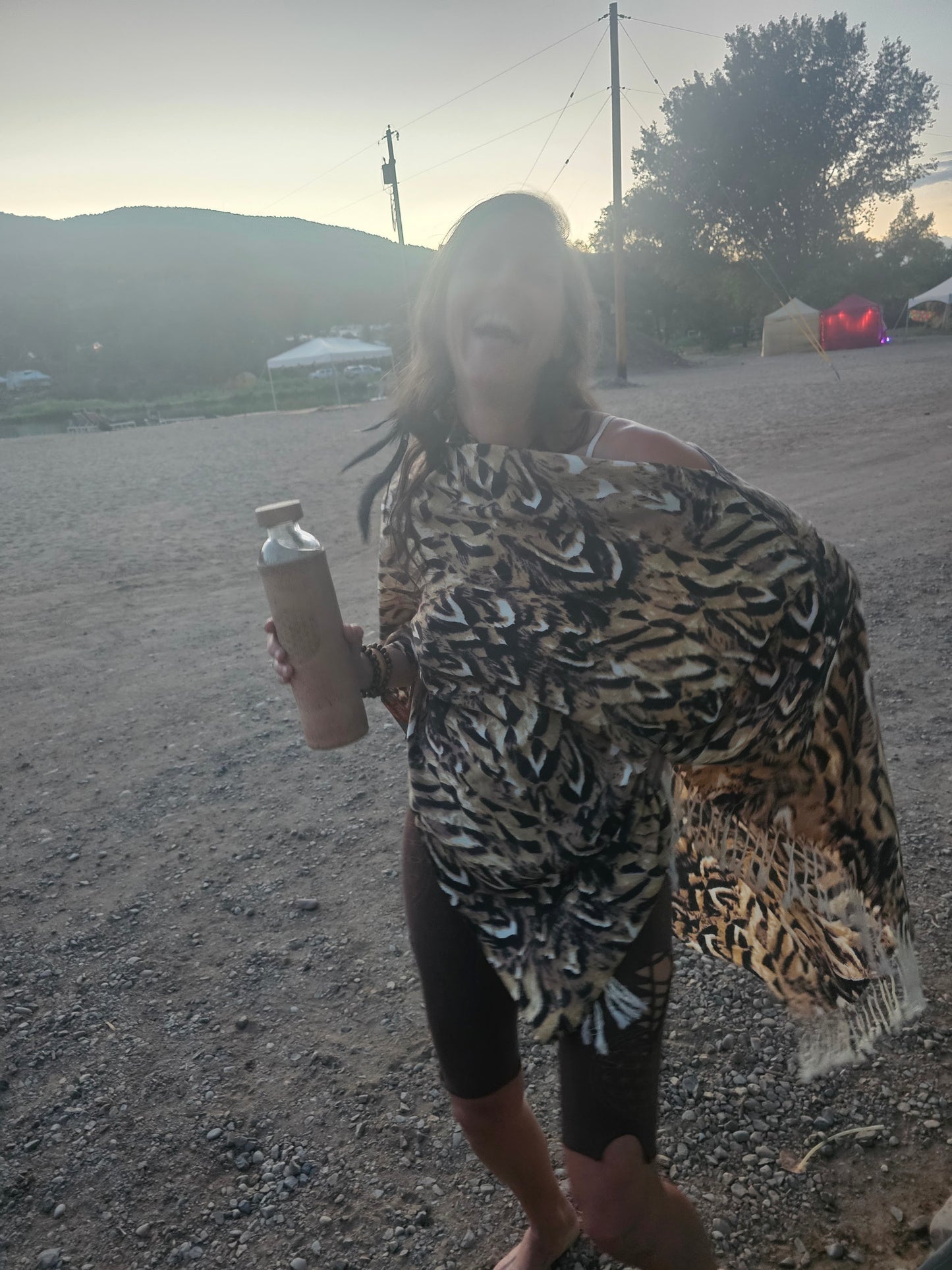 Festival goer laughing in the Owl Feather poncho scarf