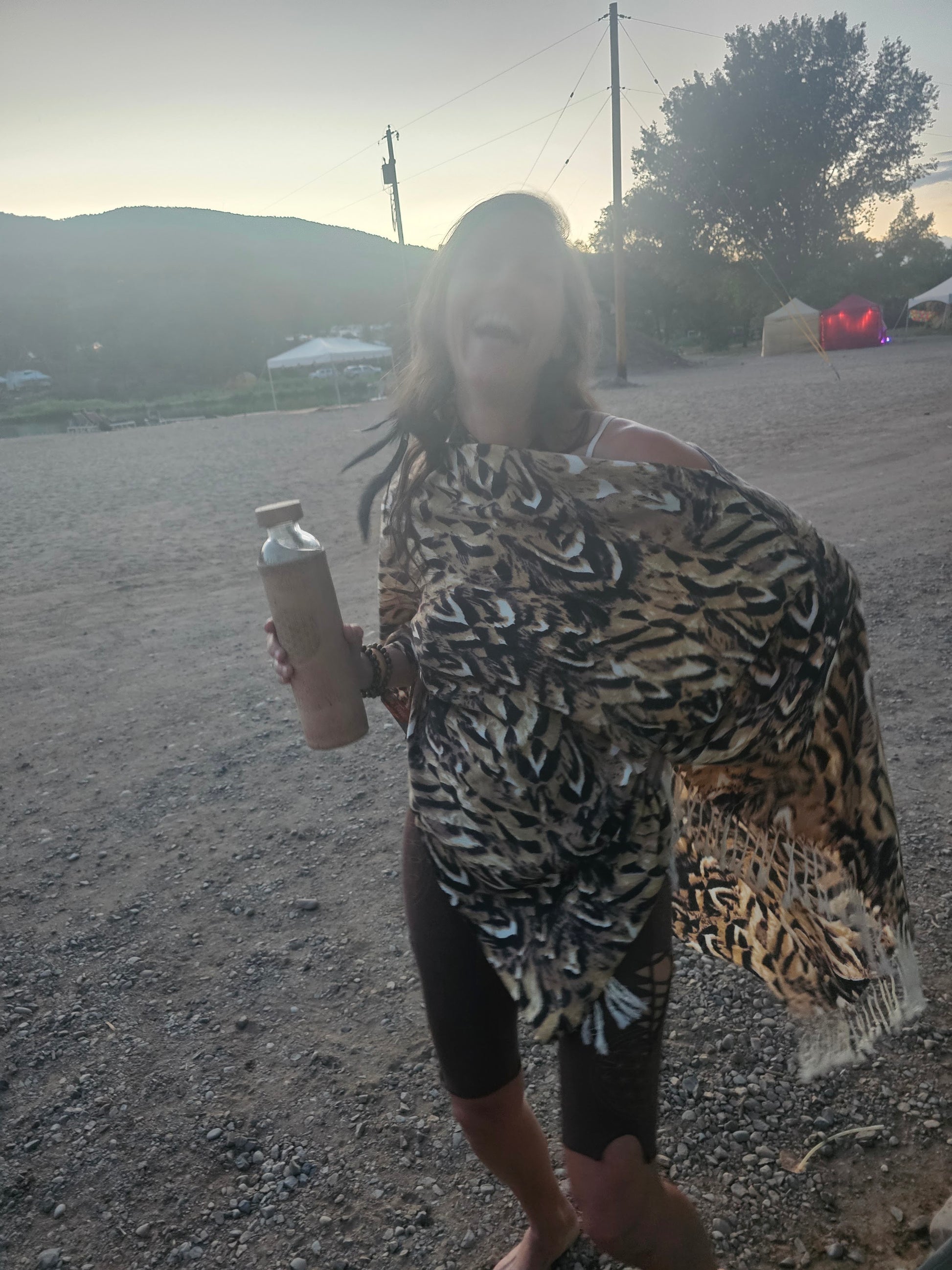 Festival goer laughing in the Owl Feather poncho scarf