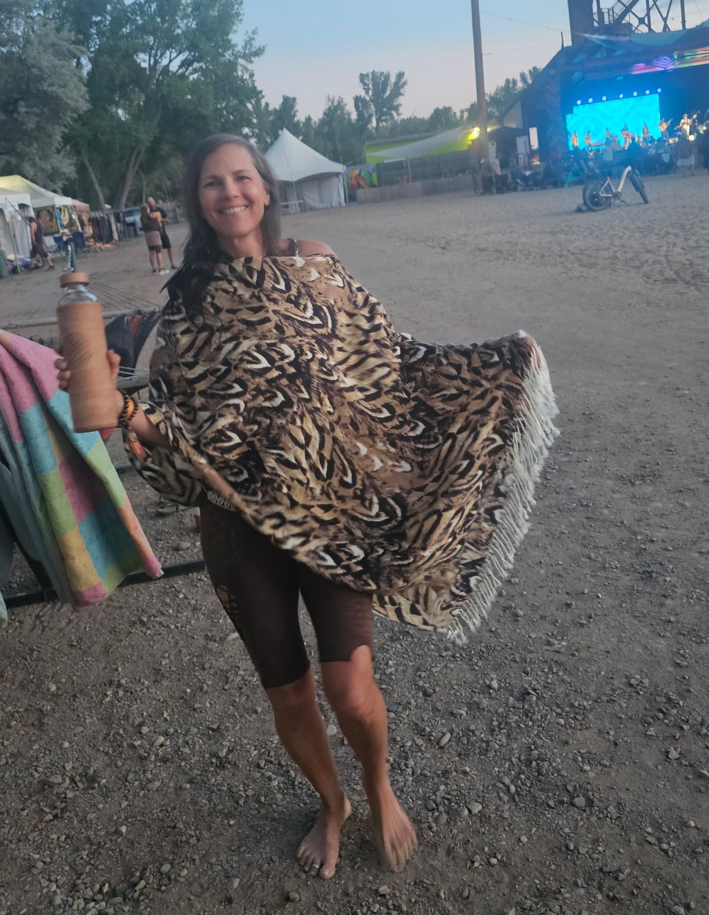 Model wearing the Owl Feather poncho scarf at a festival