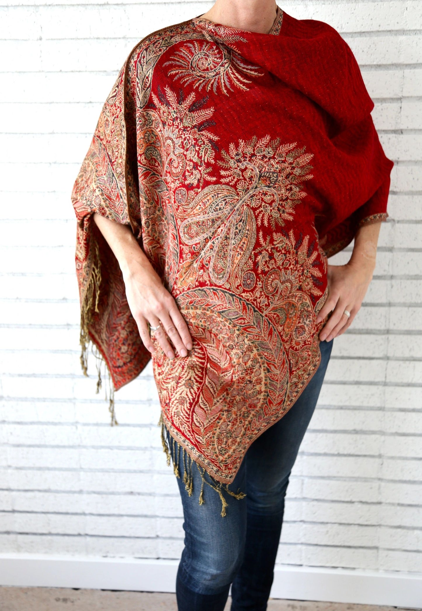 Red paisley poncho scarf worn with the seam at the side for an asymmetric drape