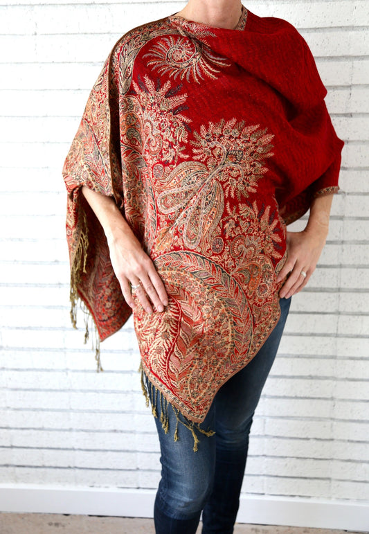 Red paisley poncho scarf worn with the seam at the side for an asymmetric drape